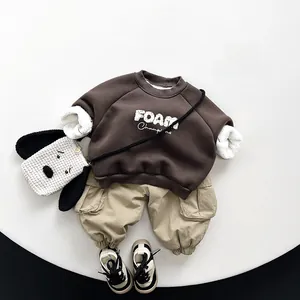 Flat lay of brown fleece sweatshirt and khaki cargo pants set for kids winter fashion