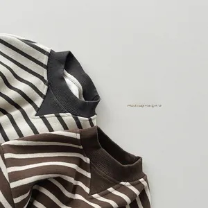 Detail of ribbed crew neck and elastic cuffs on striped children sweaters