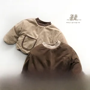 Detail of soft quilted baby sweatshirts in tan and dark brown with ribbed cuffs