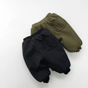 Detail view of quilted thermal kids trousers in black and army green with elastic waistband