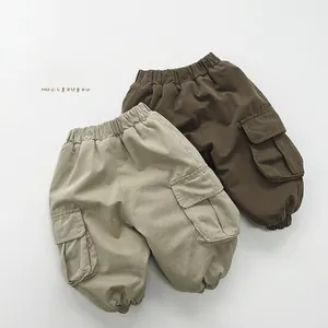 Detail showing elastic waistband and cargo pockets on beige and brown boys trousers