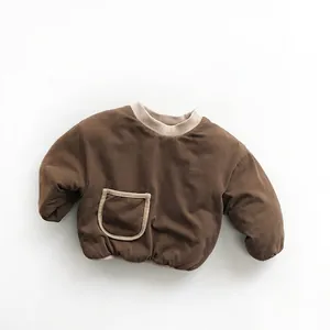Close-up detail of dark brown padded sweater featuring a soft round neck and front pocket