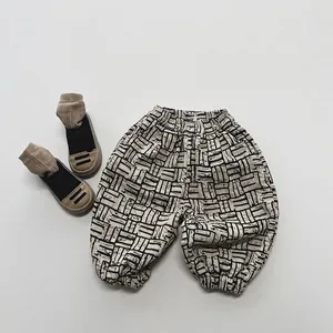 Détail du pantalon d'hiver beige pour bébés avec motif géométrique et taille élastique