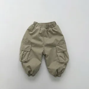 Detailed view of elastic waistband and large side cargo pockets on olive green pants