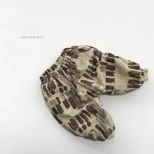 Détail de pantalon en velours beige pour enfants avec imprimé abstrait et chevilles élastiques