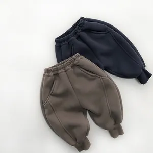 Detail of warm kids joggers with elastic waist and ribbed cuffs in navy and coffee