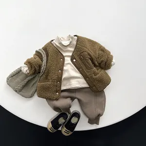 Flat lay of kids winter outfit including brown fleece jacket, joggers, and knit bag