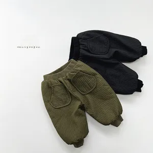 Detailed view of quilted winter trousers for kids in dark green and black colors