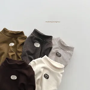 Close-up of five colorful kids thermal turtlenecks featuring ribbed fabric and patch embroidery