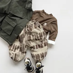 Mise à plat de vêtements en velours pour enfants avec veste verte et haut thermique