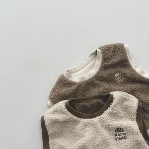 Close-up of soft sherpa fleece vests with 'warm vibes' embroidery and contrast piping