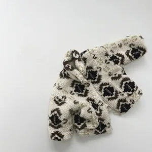 Detail of children's fleece jacket featuring ethnic geometric patterns and sturdy metal zipper