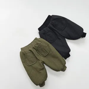 Detailed view of quilted warm winter trousers for kids with elastic cuffs and patch pockets
