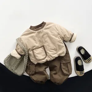 Flat lay of boys beige fleece sweatshirt and brown cargo pants with green knit bag