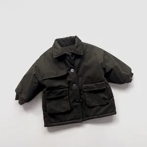 Detailed close-up of dark green children's quilted parka with large cargo pockets and lapel