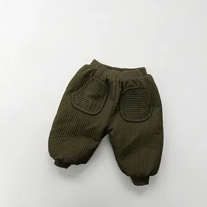 Detail of olive green quilted kids pants featuring vertical texture and ribbed cuffs