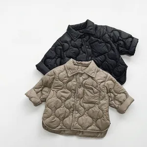 Detailed view of quilted kids jackets with onion pattern and metal snap buttons