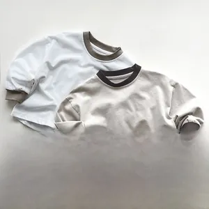 Dettaglio dei bordi a contrasto su colletto e polsini di magliette bimbi in cotone