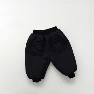 Close-up of black quilted warm pants for children with elastic waist and large side pockets