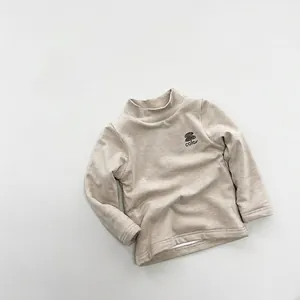 Detail of kids mock neck warm top in beige with color logo print and ribbed texture