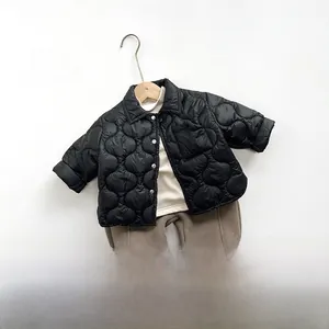 Flat lay of kids quilted black jacket, beige sweater and brown jogger set