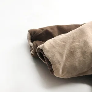 Close-up of thick ribbed cuffs on children's padded shirts in brown and beige colors