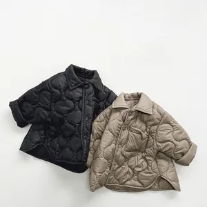 Detailed view of kids' quilted cotton jackets in black and khaki with wavy patterns