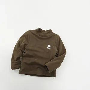 Detailed close-up of dark brown kids long sleeve fleece top with mushroom print