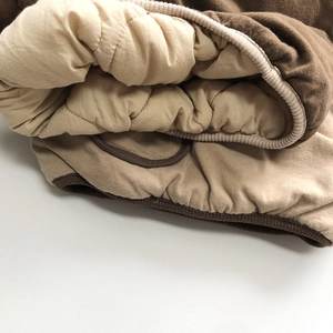 Thick padded kids top with dark brown fabric and soft ribbed cuffs for winter warmth