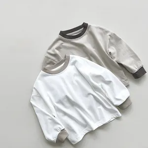 Dettaglio di due t-shirt a maniche lunghe in cotone per bambini con polsini e spalle scese