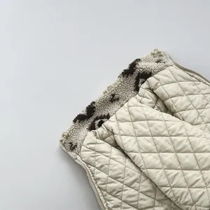 Detail view of quilted beige vest with leopard faux fur lining and diamond stitching