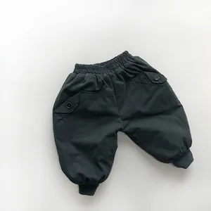 Detail view of dark green thermal pants for children with elastic waist and cargo pockets