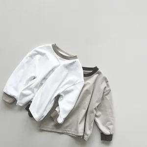 Vista dettagliata di due t-shirt a maniche lunghe in cotone con collo e polsini a contrasto