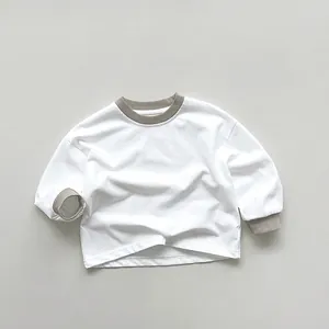 Dettaglio della maglia in cotone a maniche lunghe con scollo e polsini a coste grigie