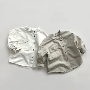 Detail of children's cotton shirts featuring stand collars and buttoned utility pockets