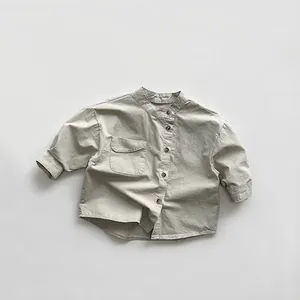 Detailed view of light gray cotton long-sleeve kids shirt with textured fabric and collar