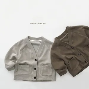 Detail view of V-neck knitted cardigans with buttons and symmetric pockets
