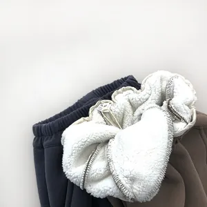 Detail of soft white fleece lining inside navy and brown thermal pants for children