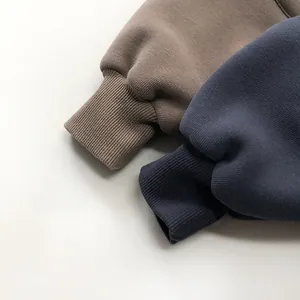 Close-up of thick ribbed cuffs on winter fleece joggers for children in brown and navy