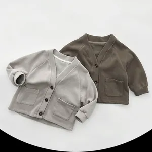 Detail of V-neck knitted cardigans with single-breasted buttons and square pockets