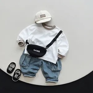 Completo bimbo con maglietta bianca a maniche lunghe, jeans cargo blu rétro e tracolla nera