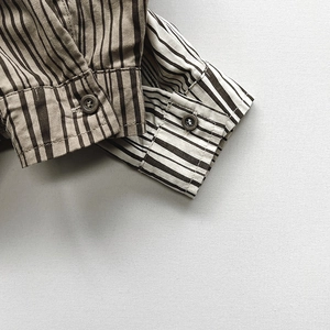Close-up of children's vertical striped cotton shirts with premium button cuff details