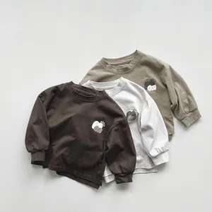 Detail of three cotton long-sleeve kids' T-shirts with heart apple print and ribbed cuffs