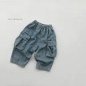 Dettaglio della vita elasticizzata e grandi tasche cargo su jeans in denim blu per bambini