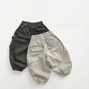 Close-up of olive green and beige kids cargo pants with elastic waist and side pockets