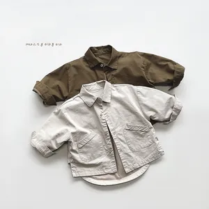 Detailed view of kids vintage cotton shirts with military pockets in green and beige