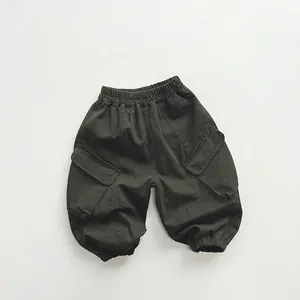 Detail of kids cargo pants showing elastic waistband and large side flap pockets