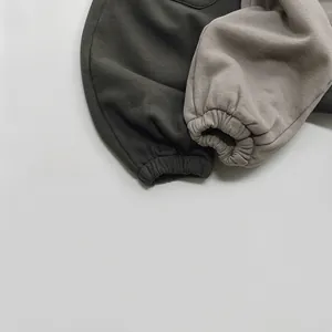 Détail des poignets élastiques sur les pantalons en tricot pour enfants en gris et beige