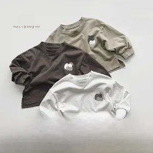 Detail of three cotton long sleeve toddler shirts with apple print and ribbed cuffs