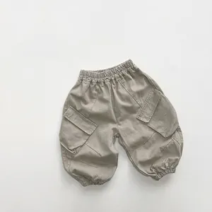 Close-up of kids cargo pants with elastic waist and large side pockets in khaki color